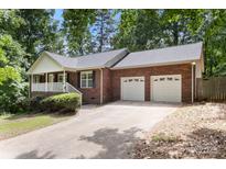 Charming brick home featuring a two-car garage and a well-manicured front yard at 410 Glass Ct, Kannapolis, NC 28081
