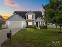 Charming two-story home featuring a well-manicured lawn and a two-car garage at 423 Courtland Ct, Kannapolis, NC 28081