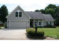 Charming home featuring an attached garage, covered front porch, and well maintained landscaping at 4711 Lenox Hill Pl # 98, Charlotte, NC 28269