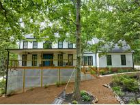 Beautiful two-story white home with black trim, large front porch, and lush landscaping at 5611 Charter Oaks Ln, York, SC 29745