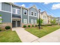 Charming townhome with manicured lawn and inviting front entrances at 711 Beaty St, Davidson, NC 28036