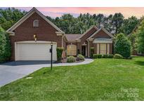 Charming brick home with manicured lawn and landscaping, plus a two-car garage and inviting walkway at 7211 Baniff Cir, Charlotte, NC 28277