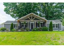 Charming gray home with a welcoming front porch and lush green lawn at 7901 Reames Rd, Charlotte, NC 28216