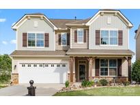 Charming two-story home with stone accents, a two-car garage, and a welcoming front porch at 112 Artisan Ct, Mooresville, NC 28117