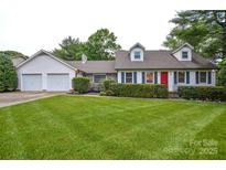 Charming single-Gathering home featuring a lush green lawn, bright red front door, and manicured landscaping at 1506 Cameron Dr, Statesville, NC 28625
