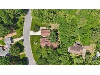 An aerial view of a brick home nestled among mature trees on a large, landscaped lot with an extended driveway at 2234 Hamilton Mill Rd, Charlotte, NC 28270
