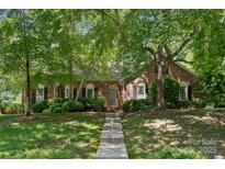 Charming brick home featuring a well-maintained lawn and mature trees providing shade and curb appeal at 2234 Hamilton Mill Rd, Charlotte, NC 28270