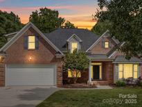 Charming brick home showcasing a well-manicured lawn, attached garage, and inviting entrance at 2608 Golden Bell Dr, Gastonia, NC 28056