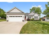 Charming single-Gathering home with a two-car garage, landscaped yard, and inviting red front door at 2996 N Lookout St, Claremont, NC 28610