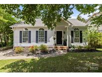 Charming single-story home with a well-manicured lawn, black shutters and arched windows at 3801 Rosedown Dr, Matthews, NC 28105