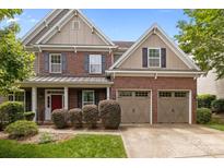 Inviting two-story brick home featuring a two-car garage and a covered front porch at 4117 Bright Rd, Charlotte, NC 28214