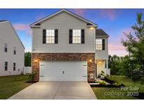 Two-story home with white siding, brick accents, dark shutters, and a two-car garage at 449 Misty Law Ln, Clover, SC 29710