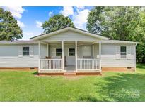 Charming single-story home featuring a cozy front porch with white railings and a well-maintained lawn at 4648 Rifle Range Rd, Conover, NC 28613