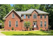 Charming two-story brick home with landscaped front yard and inviting curb appeal under a bright blue sky at 763 Evans Manor Dr, Weddington, NC 28104