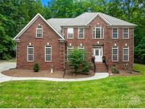 Beautiful two-story brick home with meticulously maintained landscaping and a welcoming front entrance at 763 Evans Manor Dr, Weddington, NC 28104