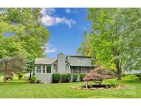 Charming home exterior features a lush green lawn, mature trees and classic architectural details at 8506 Graham Rd, Denver, NC 28037