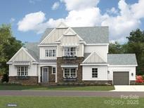 New construction boasts a modern farmhouse elevation with stone accents and a welcoming two-car garage at 1001 Kingbird Ln # 15, Clover, SC 29710