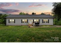 Charming single-story home with a well-manicured lawn and inviting front porch, perfect for relaxing evenings at 113 Robinette Ln, Statesville, NC 28625