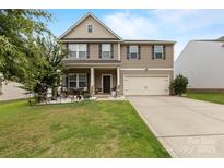 Charming two-story home features a well-maintained lawn, front porch, and two-car garage at 116 Maggie Dr, Mount Holly, NC 28120