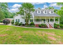Charming two-story home featuring a welcoming front porch and beautifully landscaped front yard at 132 Homeplace Ln, Statesville, NC 28625