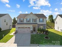 Charming two-story home with a well-manicured lawn and attached two-car garage at 1725 Mill Creek Sw Ln, Concord, NC 28025