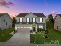 Charming two-story home featuring a well-maintained lawn, stone accents, and a spacious three-car garage at 1725 Mill Creek Sw Ln, Concord, NC 28025