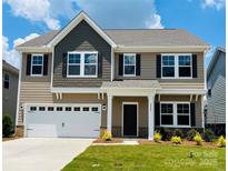 Charming two-story home showcasing a well-manicured lawn, neutral colors, and an attached two-car garage at 2023 Puddle Pond Rd, Indian Trail, NC 28079