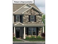 Charming two-story home featuring stone accents, black shutters, and well-manicured landscaping at 2024 Harlequin Dr, Indian Trail, NC 28079