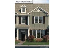 Beautifully designed townhome featuring a stone facade, black shutters, and well-maintained landscaping at 2028 Harlequin Dr, Indian Trail, NC 28079