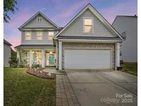 Charming two-story home with stone accents and a two-car garage under a picturesque twilight sky at 2324 Oakdale Creek Ln, Charlotte, NC 28216