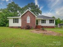 Charming single-story home featuring a brick facade, a well-manicured lawn, and lush landscaping at 4636 Brown Creek Church Rd, Wadesboro, NC 28170