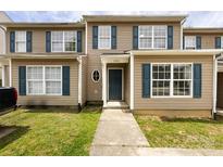 Charming townhome featuring a well-maintained front yard, tan siding, and dark blue shutters at 5343 Esther Ln, Charlotte, NC 28214