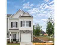 Charming two-story townhome with stone accents, a white garage door, and a well-manicured front lawn at 6009 Jasmine Branch Rd, Charlotte, NC 28216