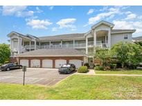 Attractive condo building with multiple levels, garage parking, and well-maintained landscaping at 8969 Meadow Vista Rd, Charlotte, NC 28213