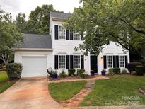 Charming two-story home featuring black shutters, attached garage, landscaped yard and a brick walkway at 9107 Royal Highlands Ct, Charlotte, NC 28277