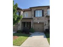 Charming townhome with stone and siding exterior, attached garage, and well-maintained landscaping at 9593 Camberley Nw Ave, Concord, NC 28027