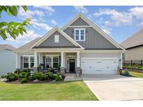 Charming single-Gathering home featuring a manicured front yard, two-car garage, and inviting front porch at 10016 St Kitts Landing Ln, Charlotte, NC 28278