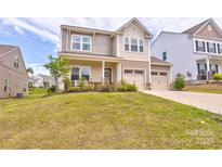 Charming two-story home featuring a two-car garage, covered porch and a well-manicured lawn at 1077 River Haven Sw Ave, Concord, NC 28025