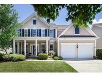 Charming two-story home with a well-manicured lawn, inviting front porch, and a two-car garage at 10792 Elsfield Nw Ave, Concord, NC 28027