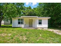 Charming home featuring a covered front porch, white siding, and well-maintained landscaping at 13821 David St, Huntersville, NC 28078