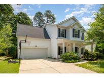 Charming two-story home with a well-manicured lawn, basketball hoop, and attached two car garage at 16121 Wrights Ferry Rd, Charlotte, NC 28278