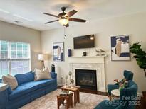 Cozy living room features a fireplace, plush blue sofa, and stylish decor at 16121 Wrights Ferry Rd, Charlotte, NC 28278