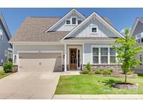 Charming home featuring a two-car garage, stone accents, and a beautifully landscaped front yard at 18013 Grey Mossrun Dr, Charlotte, NC 28278