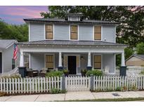 Charming two-story home featuring a welcoming front porch with seating and a classic white picket fence at 215 S Shaver St, Salisbury, NC 28144