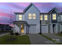 Charming townhome with neutral siding, attached garage, and well-manicured lawn at dusk at 240 Briana Marie Way, Indian Trail, NC 28079
