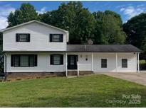 Charming two-story home with black shutters, white siding, and a well-maintained front lawn at 2412 Elizabeth Ave, Shelby, NC 28150