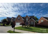 Charming two-story brick home with an attached two car garage and a well-manicured lawn at 2563 Firethorn Ct, Gastonia, NC 28056