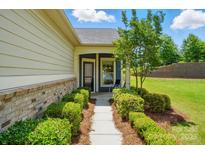 Inviting home entrance with lush landscaping and a charming walkway leading to the front door at 258 Cherrytree Dr, Fort Mill, SC 29715