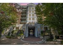 Elegant condo building entrance featuring stone columns, manicured landscaping, and a welcoming brick walkway at 300 W 5Th St # 723, Charlotte, NC 28202