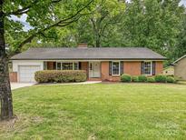Charming brick home featuring a well-maintained lawn and a manicured shrub in front at 4000 Chandworth Rd, Charlotte, NC 28210